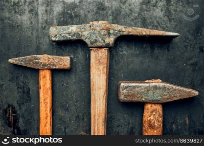 Old hammers on steel surface. Rusty tools for maintenance. Hardware tools to fix. Technical background with copy space