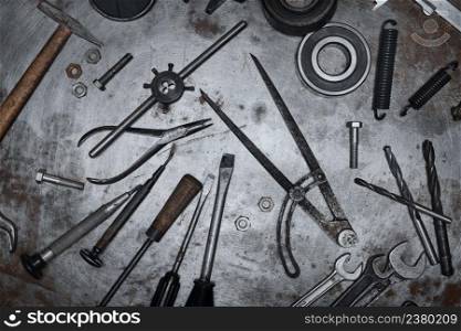 Old hand tools on metal grunge surface, flat lay