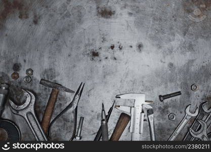 Old hand tools on metal grunge surface, flat lay