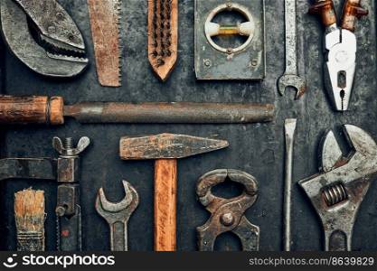 Old hardware tools. Wrench, screwdriver, measure, hammer, pliers on steel surface. Mechanic tools for maintenance. Hardware tools to fix. Technical background with copy space