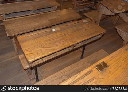 Old historic classroom with school desks.
