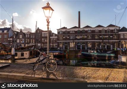 Old historic district Delfshaven with houseboats and traditional Dutch bike in Rotterdam, South Holland, The Netherlands. Old historic district Delfshaven in Rotterdam Netherlands