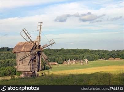 Old historical obsolete windmill and village with another windmills far away