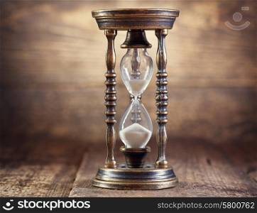 old hourglass on wooden background