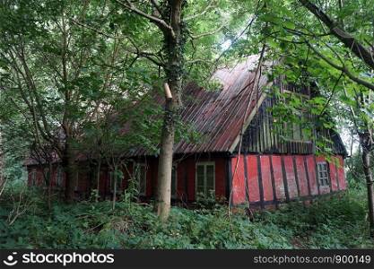 Old house in dense forest in Denmark