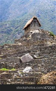 old house in Machu Picchu mountains in the background