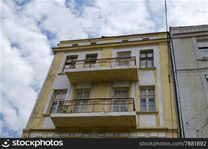 Old house with interesting facade.Metal ornament fence of balcony and gypsum figure of wall. Must to be renovate.