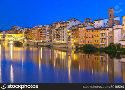 Old houses and tower on the embankment of the River Arno and Ponte Vecchio at night, Florence, Tuscany, Italy