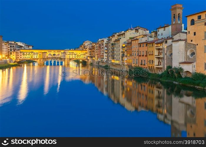 Old houses and tower on the embankment of the River Arno and Ponte Vecchio at night, Florence, Tuscany, Italy