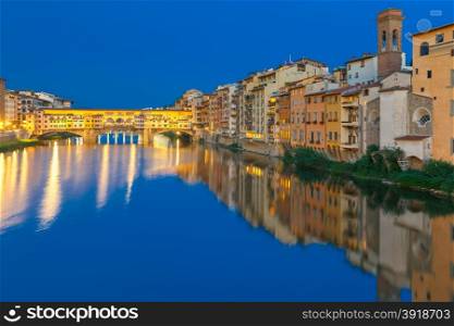 Old houses and tower on the embankment of the River Arno and Ponte Vecchio at night, Florence, Tuscany, Italy