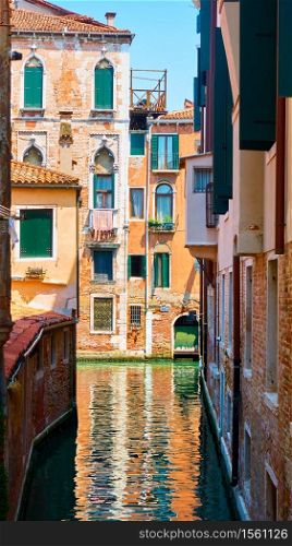 Old houses by narrow side canal in Venice, Italy. Venetian cityscape