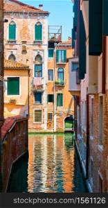 Old houses by narrow side canal in Venice, Italy. Venetian cityscape