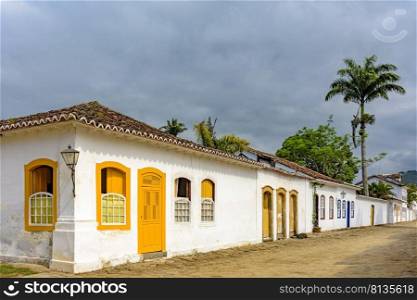 Old houses in colonial architecture and cobblestone streets in the historic city of Paraty on the south coast of Rio de Janeiro. Old houses facades in colonial architecture and cobblestone streets with cloudy sky