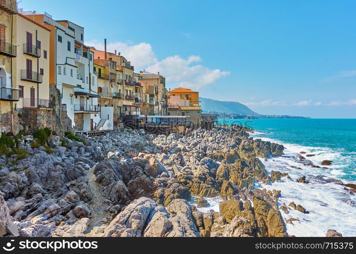 Old houses on rocky coast in Cefalu town, Sicily, Italy