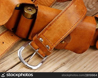 Old hunting cartridges and bandoleer on a wooden table