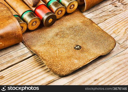 Old hunting cartridges and bandoleer on a wooden table