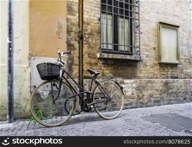 Old Italian bicycle on sunlight. Ancient buildings