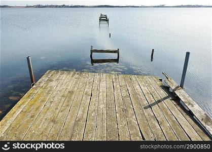 Old jetty wooden walkway pier on the lake