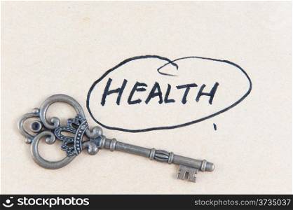 Old key and health word written on the paper