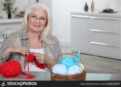 Old lady knitting in kitchen
