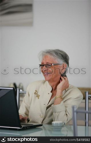 Old lady laughing at laptop