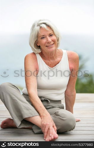 Old lady sat on wooden walkway