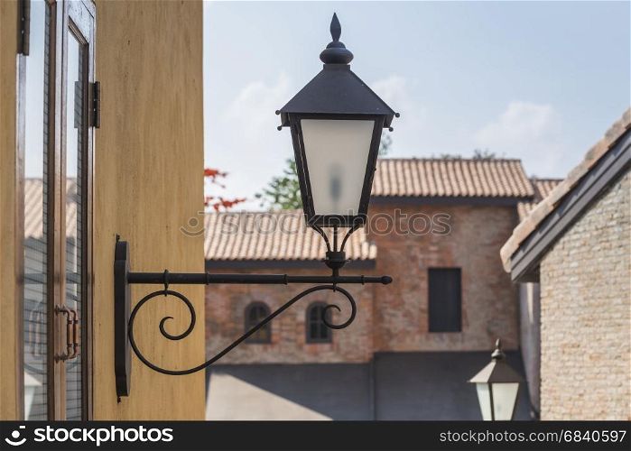 old lamp on the wall with vintage building background