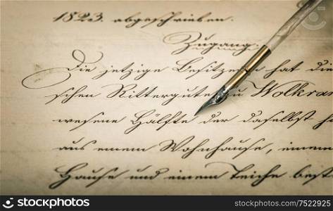 Old letter with calligraphic handwritten text and vintage ink pen. Retro style background with vignette