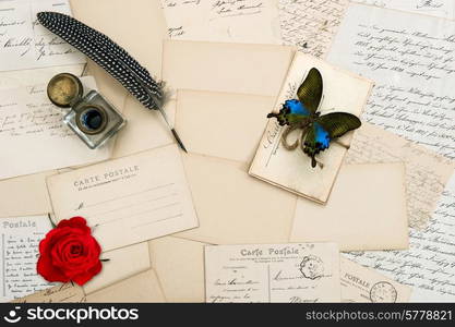 old letters, handwritings, vintage postcards and antique feather pen. nostalgic sentimental background with butterfly and red rose flower. Valentines Day concept