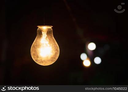 old lightbulb glowing on dark background