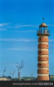 old lighthouse in Lisbon Portugal, red brick lighthouse on blue sky