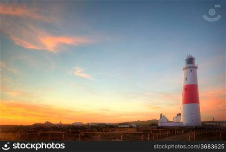 Old lighthouse is bathed in sunlight during beautiful sunset in Summer