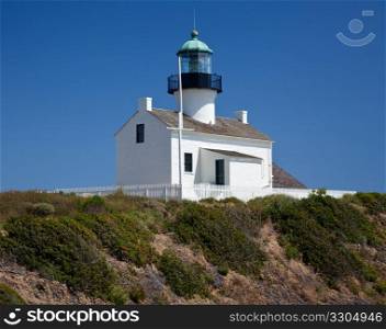 Old lighthouse on Point Loma near San Diego with a bright blue sky framing the shot