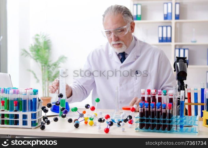 Old male chemist working in the lab 