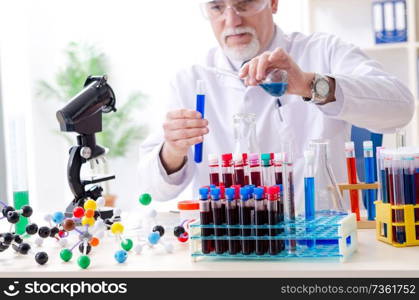 Old male chemist working in the lab 