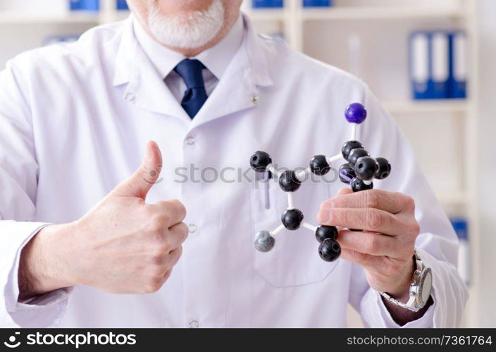 Old male chemist working in the lab 