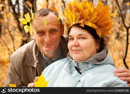 Old man and old woman with wreath of maple leaves
