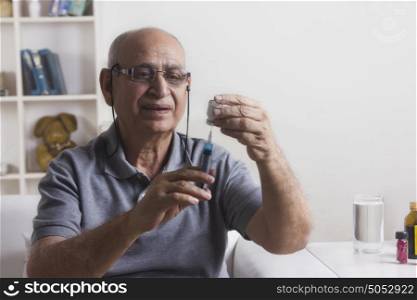 Old man filling syringe with insulin