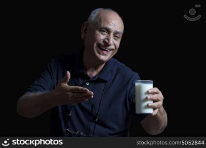 Old man gesturing to glass of milk