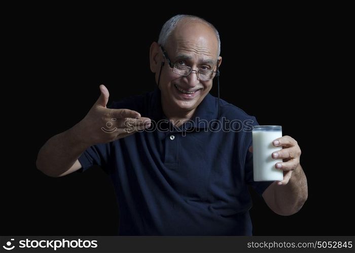 Old man gesturing to glass of milk