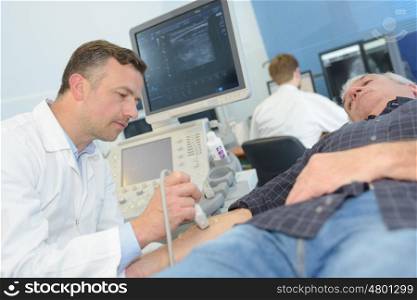 old man getting ultrasound from doctor in hospital