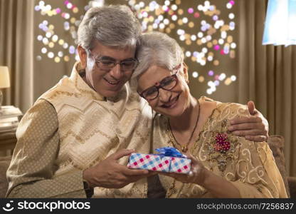 Old Man giving Diwali gift to his wife on diwali celebrations