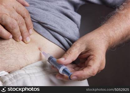 Old man giving himself insulin injection