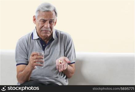 Old man holding his medicine in his hand