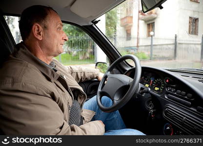 Old man in car in rain