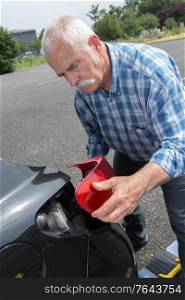 old man installs tail light on the vehicle