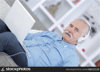 old-man listening to music from his laptop