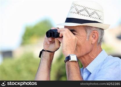 Old man looking through binoculars