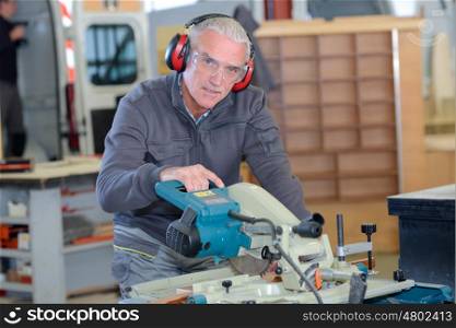 old-man man using a machine in a workshop