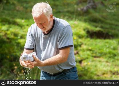 Old man pressing his own laundry in the middle of nature